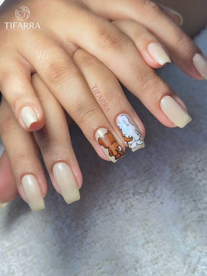 A full view of the coordinated character nail art set, showing the clean nude polish on the other nails.