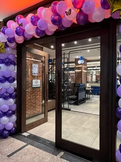 The entrance to the butterfly-themed party, with a balloon arch and a personalized welcome sign.