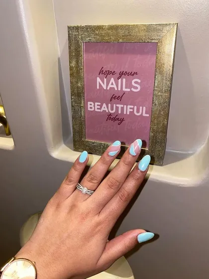 This abstract design is perfect for summer. We combined a bright sky blue base with soft pink and white swirls for a fun, modern look on almond-shaped nails.