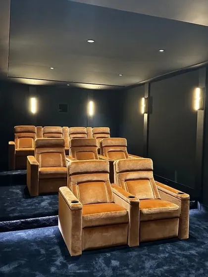Comfort is key in any theater. This view shows a multi-row layout with plush, velvety recliners. The tiered seating ensures everyone has a perfect, unobstructed view of the screen, making it ideal for larger groups of friends or family.