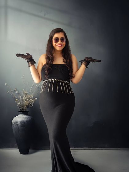 A solo portrait full of confidence and style. This shot captures the mother-to-be's personality with a fun, hands-up pose and cool sunglasses.