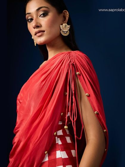 A detailed shot of Aapro's Seona Draped Dress, highlighting the shoulder draping and button details.