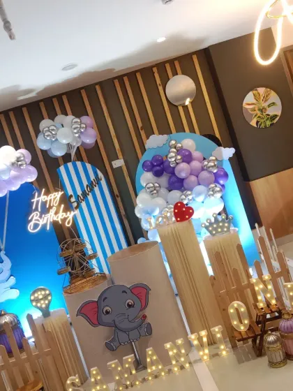 An angled view of the elephant-themed first birthday, showing the layered backdrops and balloon clouds.