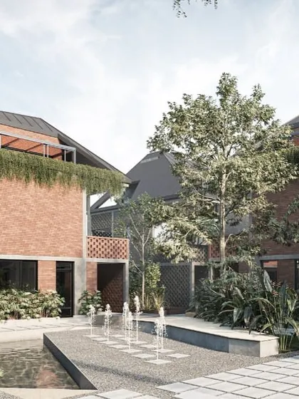 A water court serves as a central feature in this Kolgaon community space, surrounded by brick townhouses with integrated green terraces. The sound and sight of water add a sensory dimension to the landscape, creating a tranquil gathering spot.