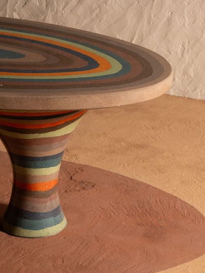 The flared pedestal leg of the Weavers Ant Table, showcasing the continuous, hand-poured color bands that give the piece its unique character and visual rhythm.