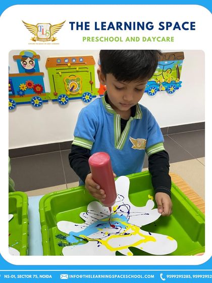 Squeezing colors onto a paper splash. This activity is great for strengthening hand muscles and learning about color mixing during our Holi festivities.