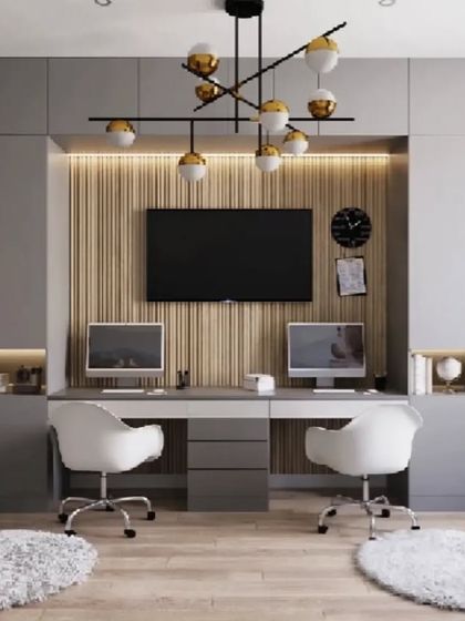 We designed this shared home office for two, featuring a long desk and floor-to-ceiling storage. The central TV and fluted wood panel add a touch of style, while the grey cabinets and integrated lighting keep the space feeling modern and organized.