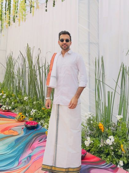 A full-length view of my South Indian attire against a colorful, modern backdrop. I ensure my look complements the event's decor and theme perfectly.