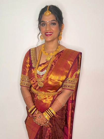A smiling portrait that shows off the complete traditional look. The makeup is polished and radiant, ensuring the bride looks her absolute best.