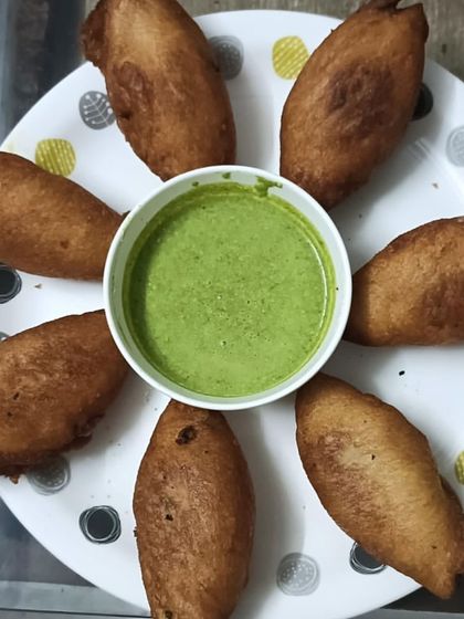 A plate of crispy bread rolls served with fresh mint chutney. A perfect evening snack.