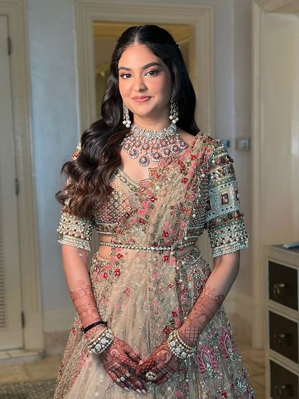 A smiling portrait of the bride-to-be. The makeup is soft and luminous, enhancing her natural beauty for this special occasion.