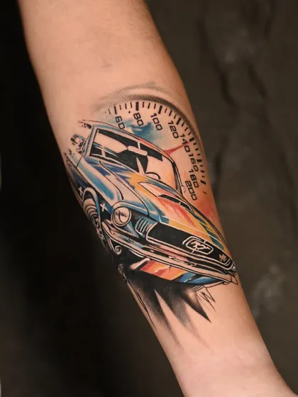 We love a challenge, and this micro-realistic color tattoo of a classic car was a joy to create. The vibrant watercolor splash effect combined with precise line work on the speedometer shows our ability to merge different artistic styles into one dynamic piece.