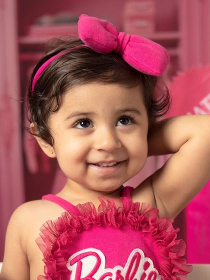 A series of close-up portraits showing the many adorable and happy expressions of a little girl during her Barbie-themed session.