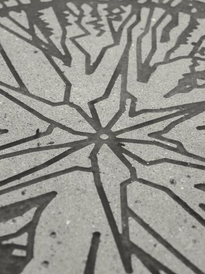A macro shot of the artwork on our concrete table, revealing the fine lines and texture created by the etching process.