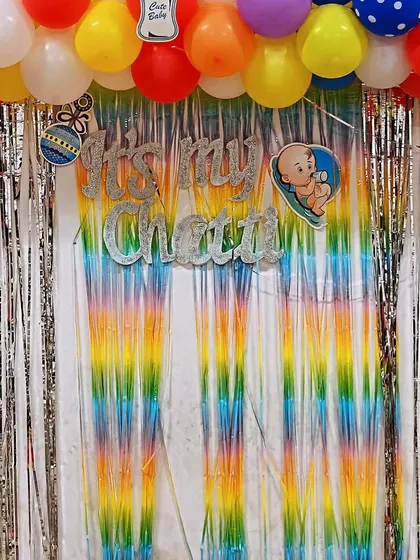 A close-up of the "It's my Chatti" sign from the newborn ceremony decor, showing the glittery letters against the colorful backdrop.