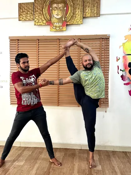 Partner work is for everyone. Here, I assist a male student in a standing split, demonstrating that flexibility and balance are goals we work towards with all our clients.