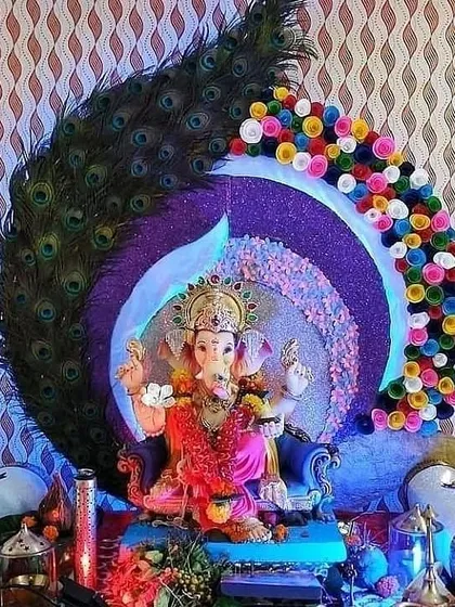 This is another take on the popular peacock theme for Ganpati. I used a large arch of real peacock feathers combined with colorful paper flowers to create a unique and artistic backdrop for the idol.