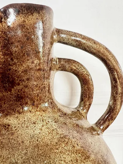 A close-up of the handle detail on the large, rustic hand-built vase.