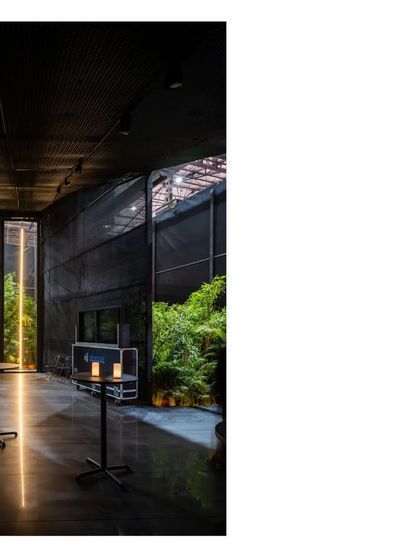 A view from inside the Durall Pavilion, where a single person pauses by the vertical window. The all black mesh form creates a space for quiet, allowing the garden and the light to become the focus.