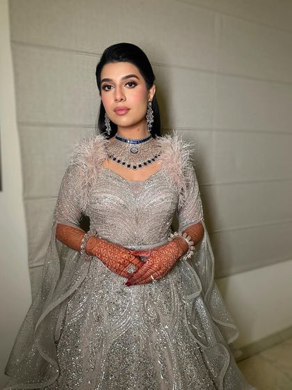 The full look, showcasing the stunning feathered gown and the glamorous makeup that completes the ensemble.