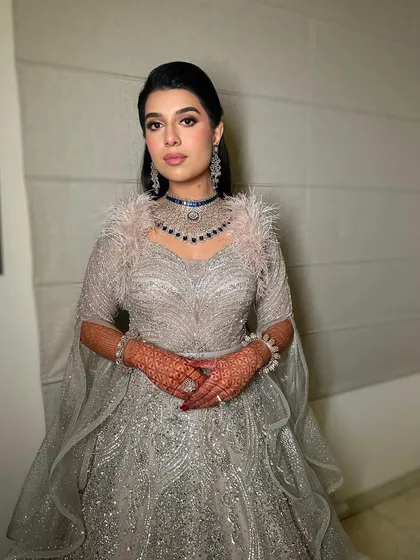 The full look, showcasing the stunning feathered gown and the glamorous makeup that completes the ensemble.