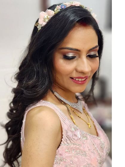 Isn't she looking like an absolute doll? Her reception look is soft and romantic, with a beautiful floral headband and shimmery silver eye makeup.