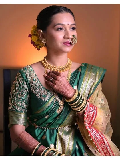 The elegance and glow of filter-free makeup is real. Leenal's traditional Marathi wedding look featured a flawless base, defined eyes, and a bold lip that perfectly matched her green nauvari saree.