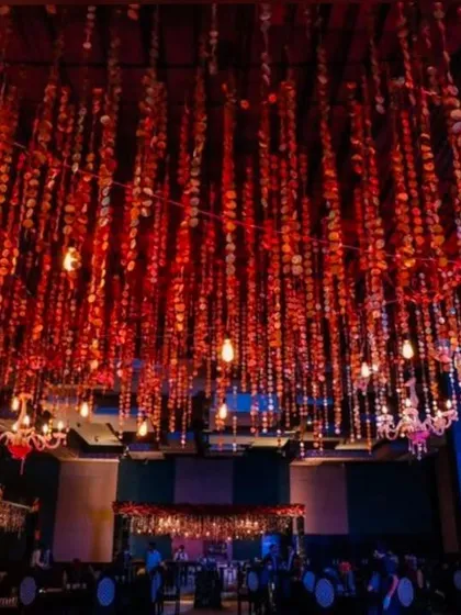 A ceiling view of a sangeet hall, where I used hundreds of hanging red sequin strings and vintage bulbs. This creates a mesmerizing effect over the entire space.