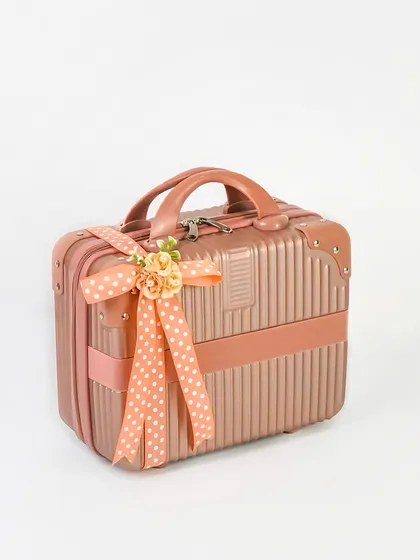 A product shot of a rose gold mini-suitcase used as a gift box. The clean white background and elegant ribbon make it look like a premium and unique packaging option.