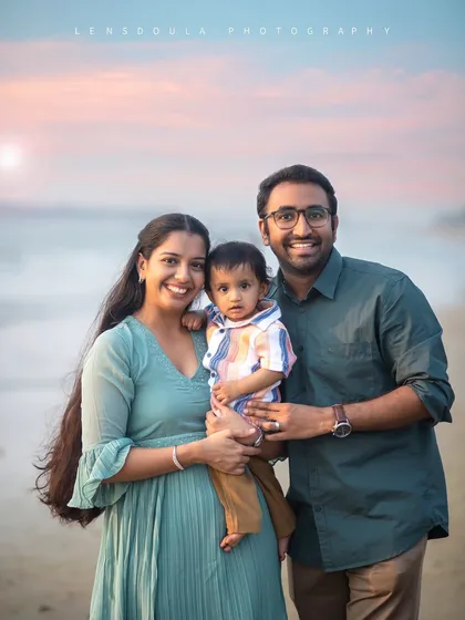 A perfect family-of-three portrait on the beach. Everyone is smiling, happy, and enjoying the beautiful evening together.