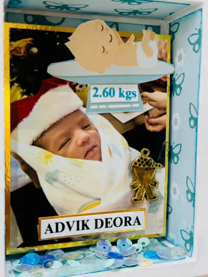 A close-up of the baby's photo with his name, 'Advik Deora', and his birth weight, a precious detail for the family to remember.