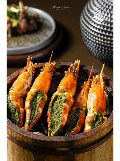 Large river prawns stuffed with a green herb paste, presented in a wooden bucket for Shang Palace.