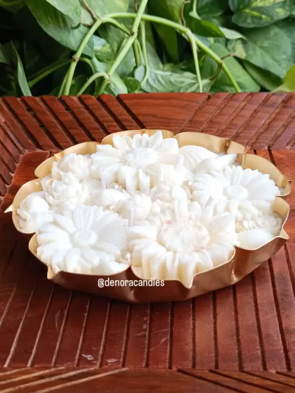 An elegant, all-white floral urli candle displayed on a carved wooden surface. This design is versatile and fits beautifully into both traditional and contemporary home decor settings.