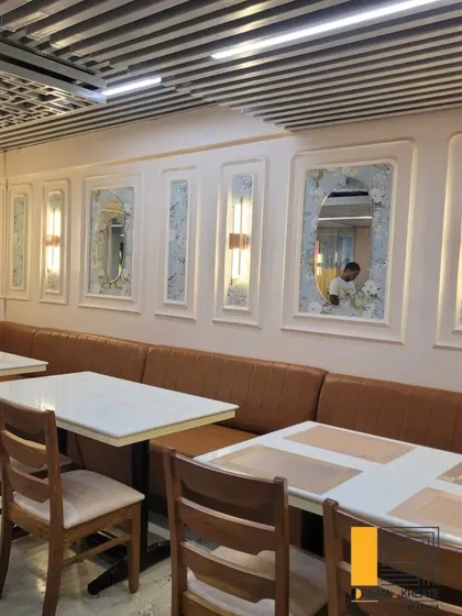 A close-up of the booth seating, showing the comfortable upholstery and the decorative wall panels with integrated lighting and mirrors.