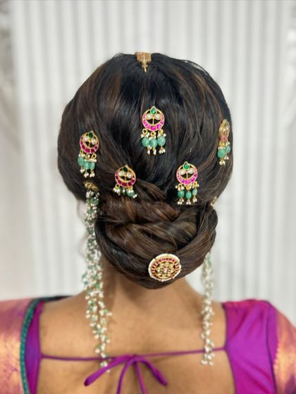 A clear back view of the stunning jewellery-adorned updo, a perfect choice for a bride wearing a silk saree.