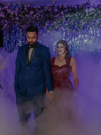 A grand, smoky entrance for the Sangeet night, with the couple looking glamorous and ready to celebrate.