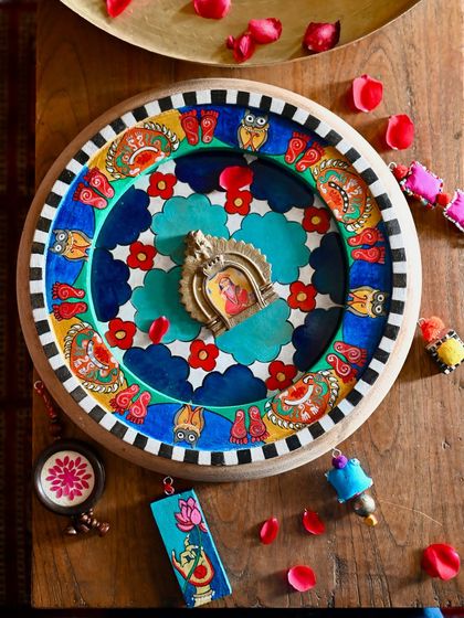 This is my hand-painted homage to Laxmi, the goddess of prosperity, set within a reclaimed clock frame. The artwork is filled with symbols like owls and lotuses, all rendered in the Pattachitra style and surrounded by colorful, found-object trims.