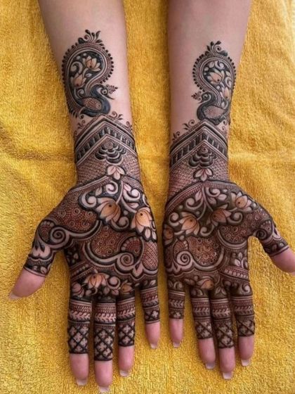 Elegant peacock motifs are the centerpiece of this design, with their feathers flowing gracefully down the hands. A classic and beautiful choice.