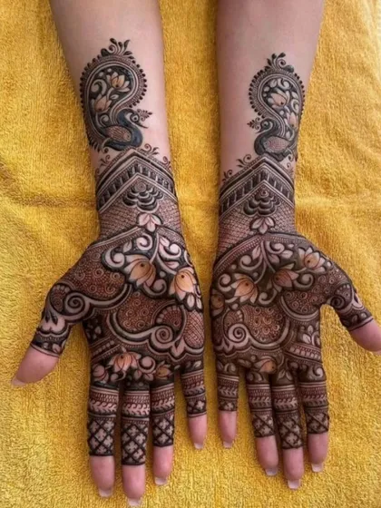 A classic and elegant design featuring graceful peacocks at the top of the wrist. The palms are filled with delicate floral and paisley patterns, perfect for an engagement or sangeet ceremony.