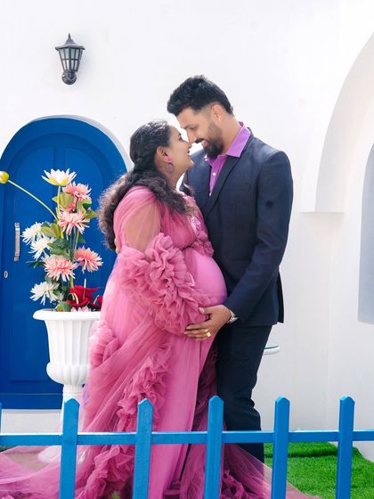An intimate portrait of a couple at the Santorini set. The soft pink of her gown contrasts beautifully with the bold blue door, creating a romantic and colorful image.