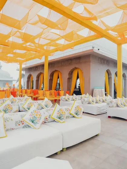 Comfortable and stylish lounge seating with printed cushions under a yellow canopy, perfect for guests to relax and enjoy the Haldi festivities.