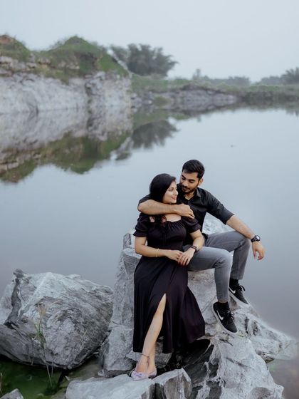 The quiet intimacy of a couple sitting by the water. The reflection on the lake and the soft light add a layer of tranquility to this romantic pre-wedding photograph.