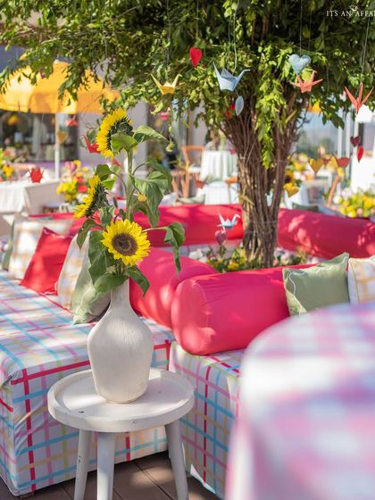A close-up of the seating area around the tree, with sunflowers in a vase adding a bright pop of yellow.
