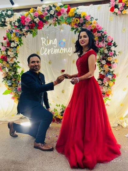 The moment he proposes during their ring ceremony. The bride-to-be looks radiant in a classic red ball gown.