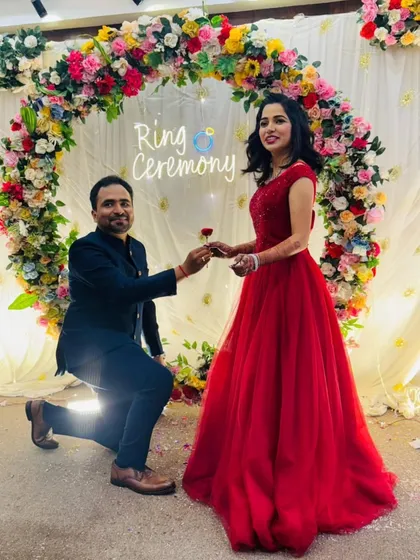 The moment he proposes during their ring ceremony. The bride-to-be looks radiant in a classic red ball gown.