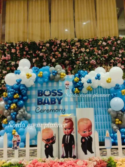 A closer look at the Boss Baby backdrop, combining a blue gingham pattern with a balloon arch and a flower wall for a full and festive look.
