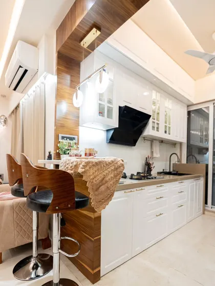 We designed this open-concept kitchen to be the heart of the home. The classic white cabinetry and a warm wooden breakfast bar create a welcoming space for cooking, conversation, and connection with the living area.