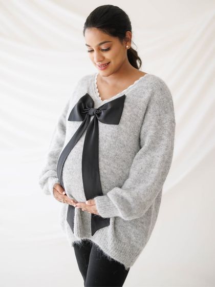 A gentle and loving portrait of a mother-to-be, her hands cradling her bump, radiating peace and happiness.