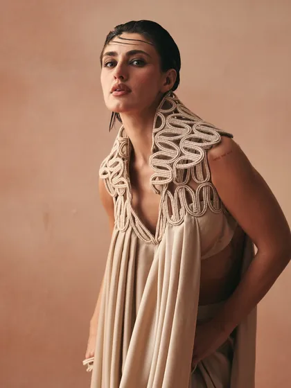 The Kashar tunic features a fluid cowl-drape anchored by a statement corded collar. This avant-garde piece balances weight and whisper, reimagining traditional drapes.