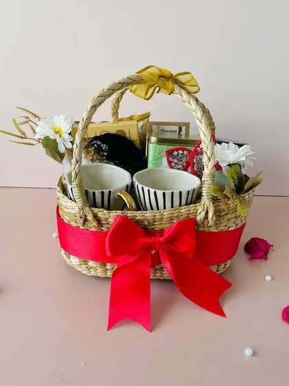 For a touch of rustic elegance, I offer these stunning Kauna oval baskets. This hamper is filled with premium items like striped ceramic mugs and gourmet treats, making it a thoughtful and sustainable gift choice.